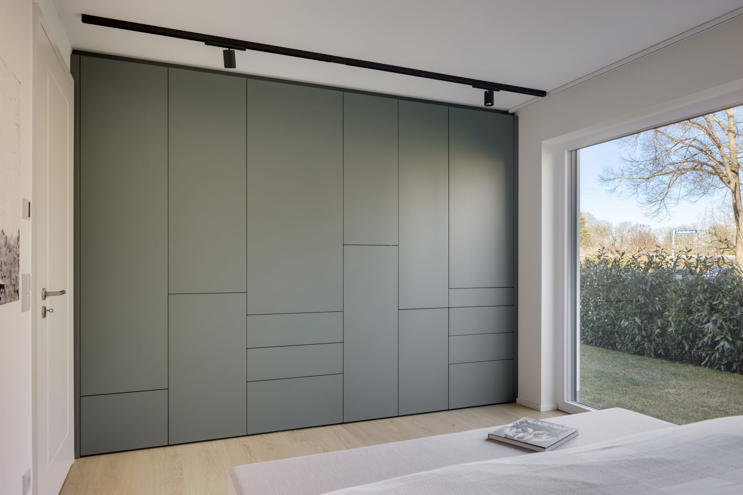 Grüner Einbauschrank mit geometrischem Fugenbild im modernen Schlafzimmer