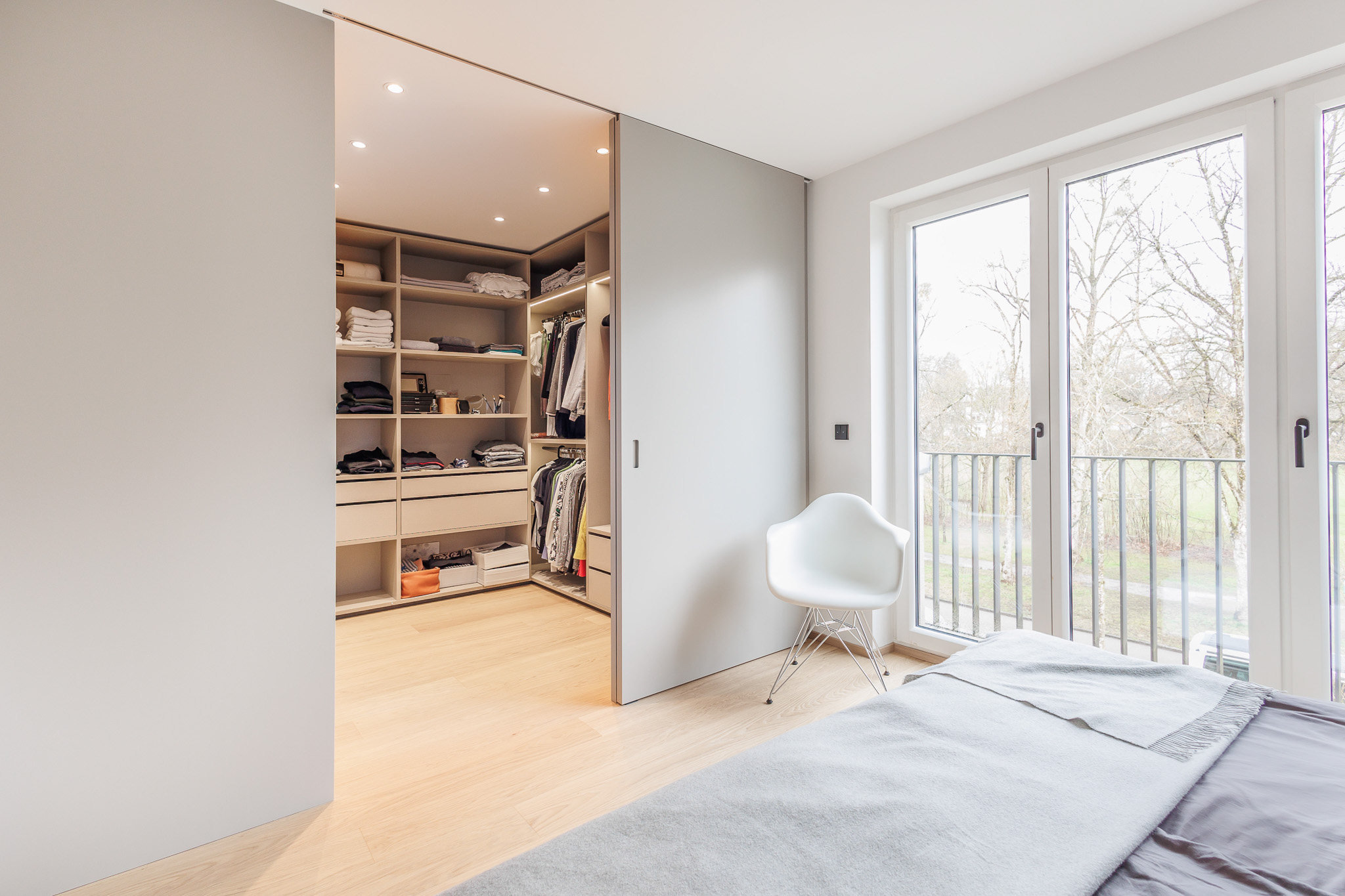 Ankleidezimmer, raumhoher Einbauschränke mit Schubladen und Kleiderstange im minimalistischen Design