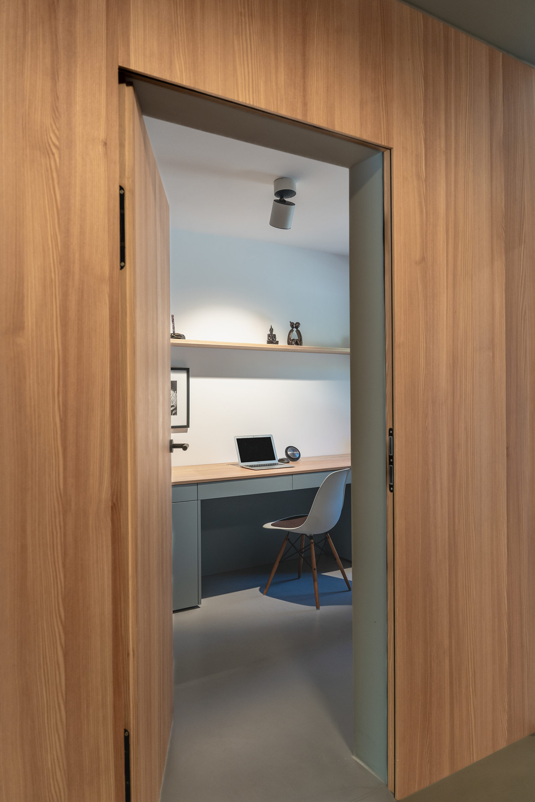 Modernes Arbeitszimmer in Schwabing mit versteckter Tapetentür und minimalistischer Wandverkleidung