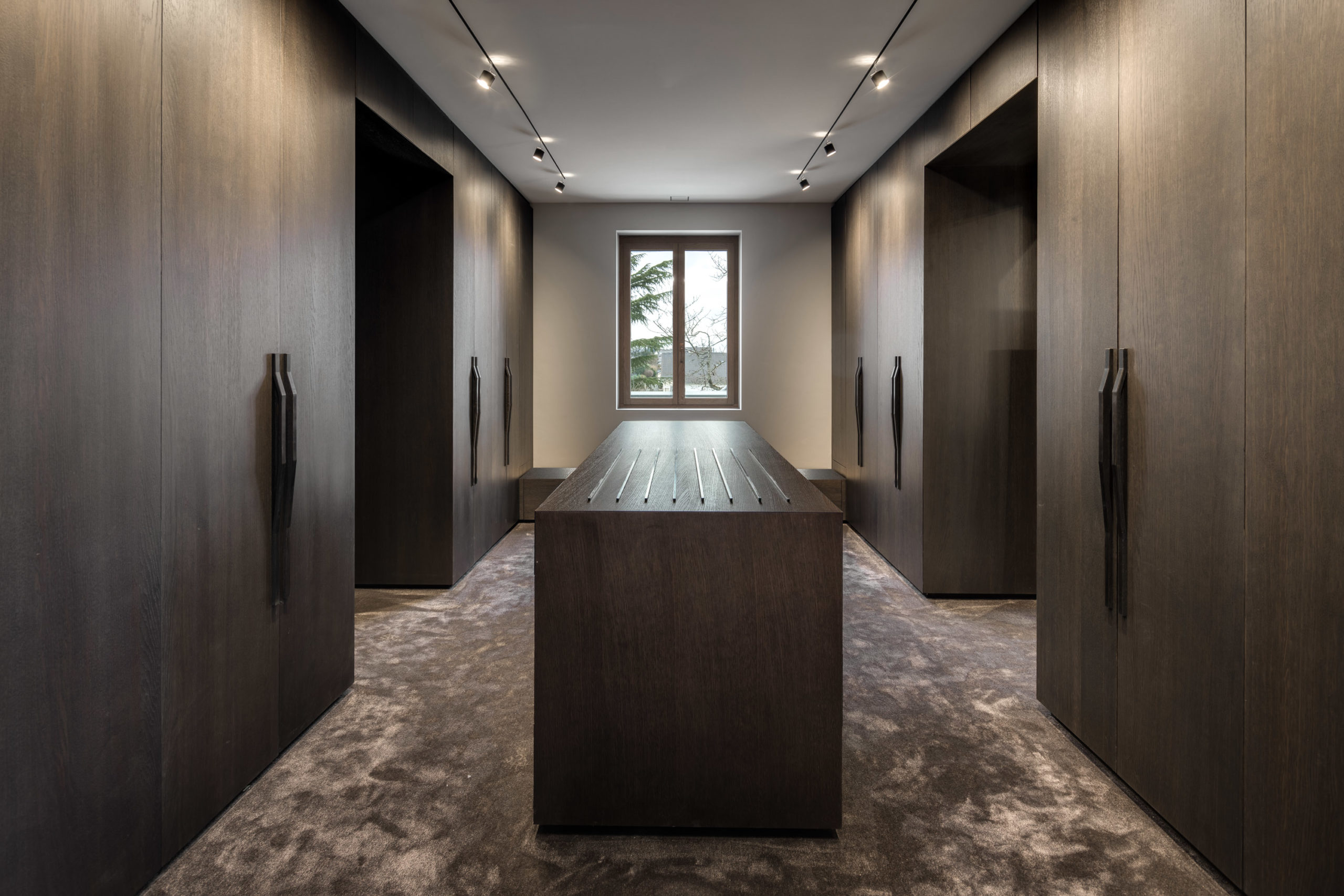 Luxuriöser begehbarer Kleiderschrank mit Mittelinsel und dunklen Holzfronten