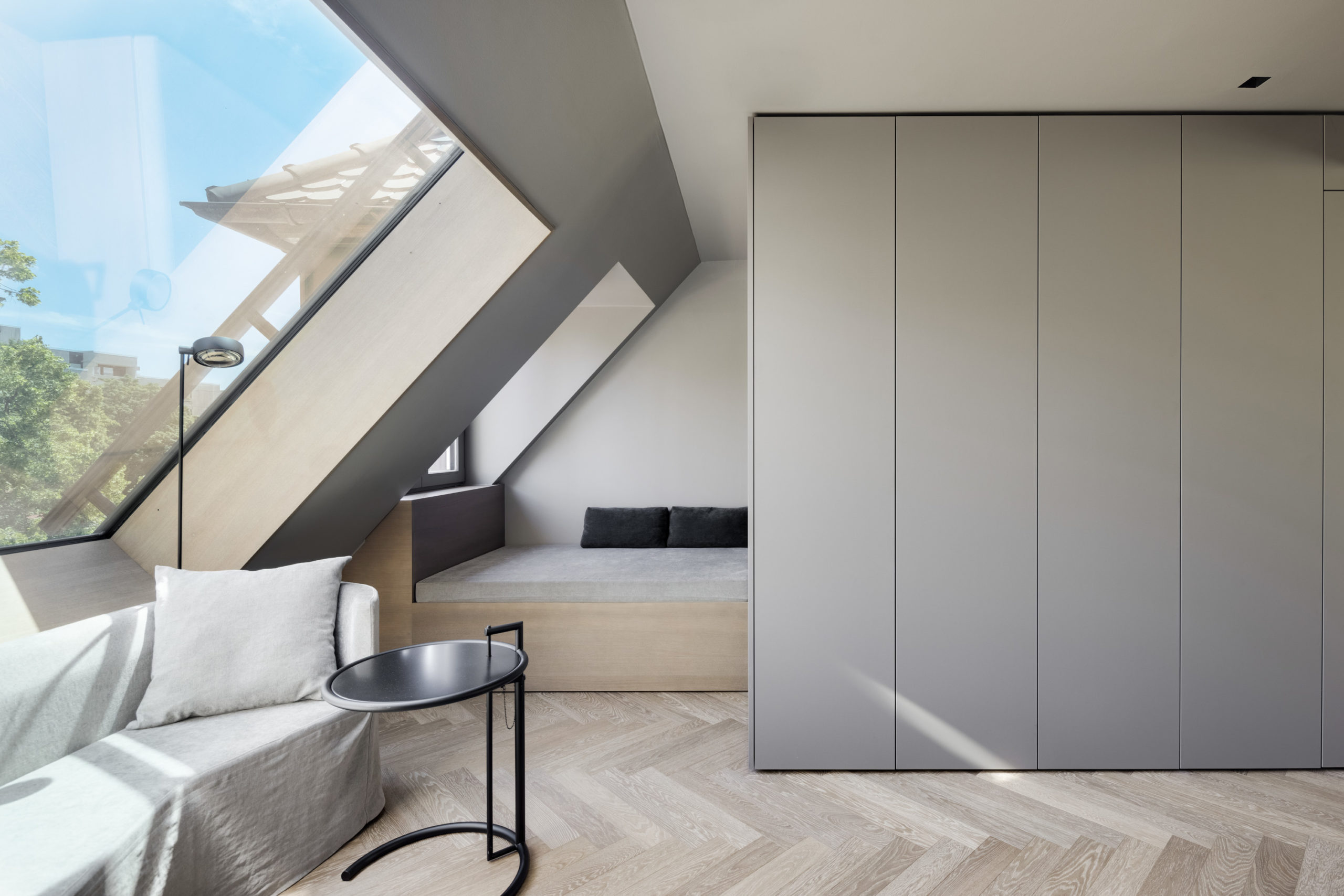 Heller Dachgeschoss-Wohnbereich mit großem Schrägfenster und Einbaumöbeln