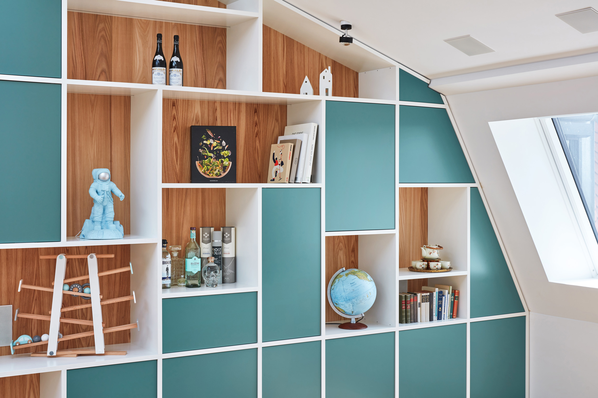 Detailansicht der Regalwand mit Holznischen, Globus und Dekorationholzverkleideten Fächern
