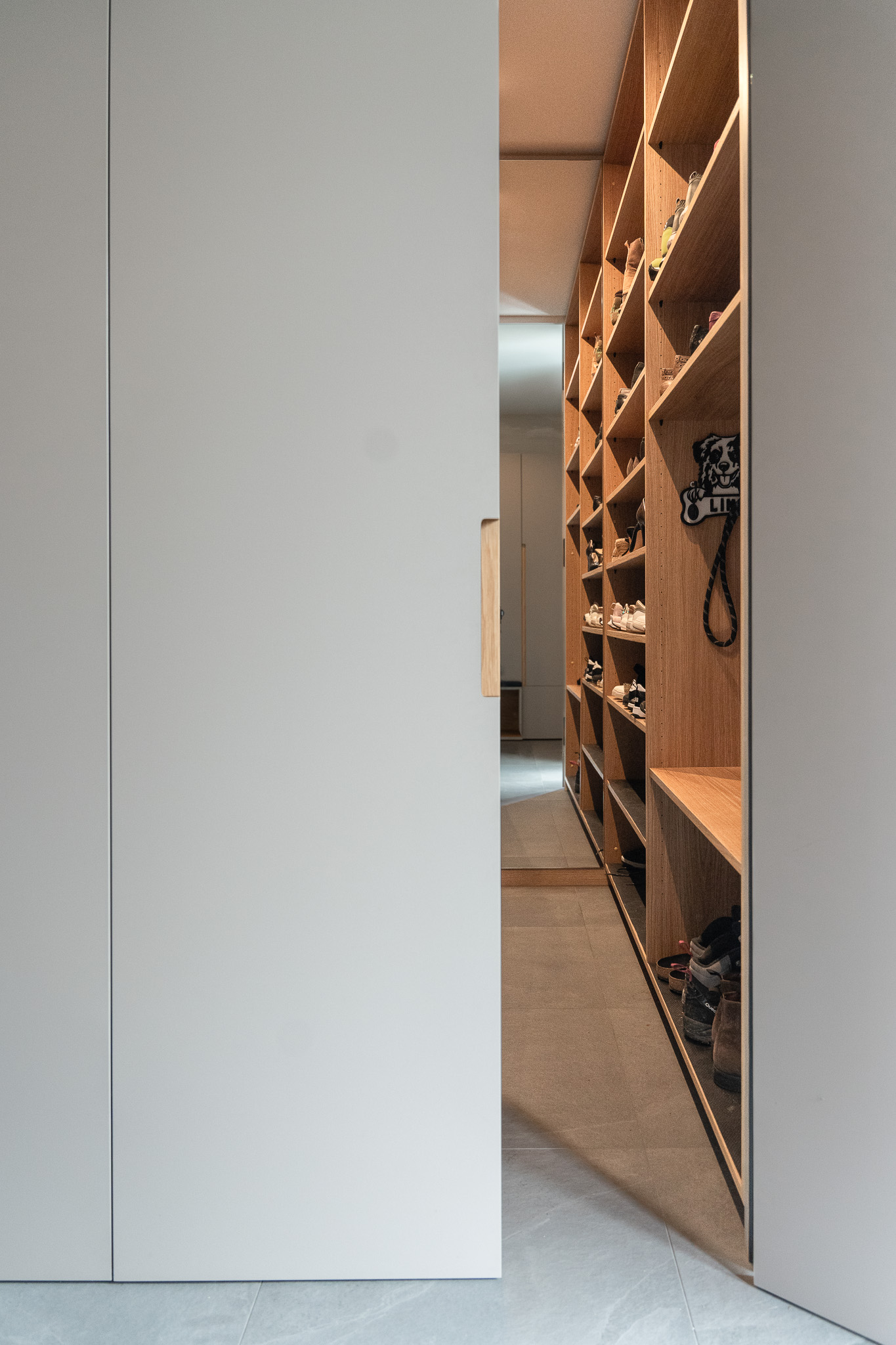 Geöffneter Garderobenschrank mit großzügigem Stauraum und eleganter Griffmulde aus Holz