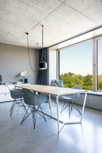 Minimalistischer Essbereich in einer Wohnung mit Holztisch und Designerstühlen
