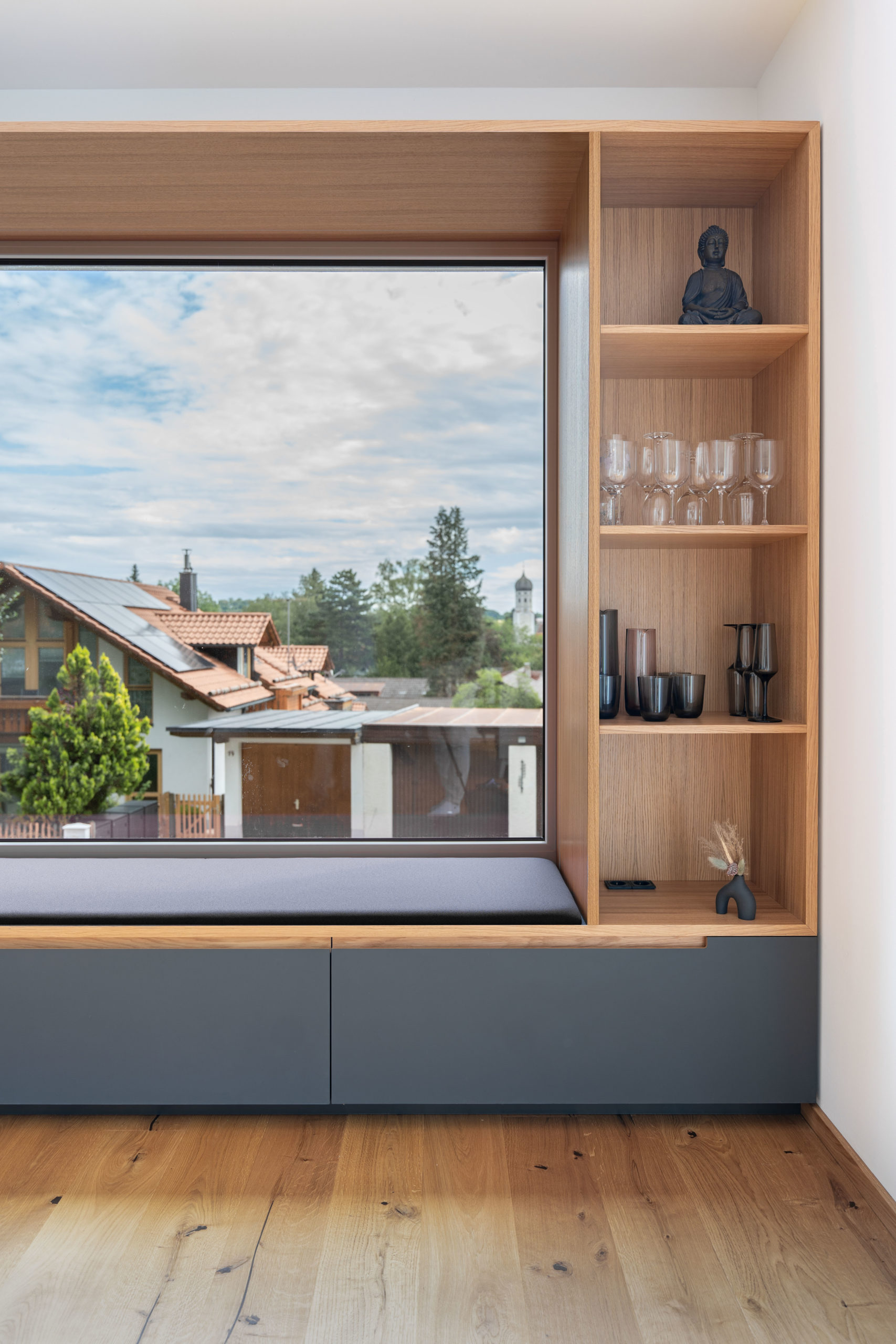 Fenstersitz mit integriertem Stauraum und Regalen in Eiche und Anthrazit – modernes Wohnkonzept