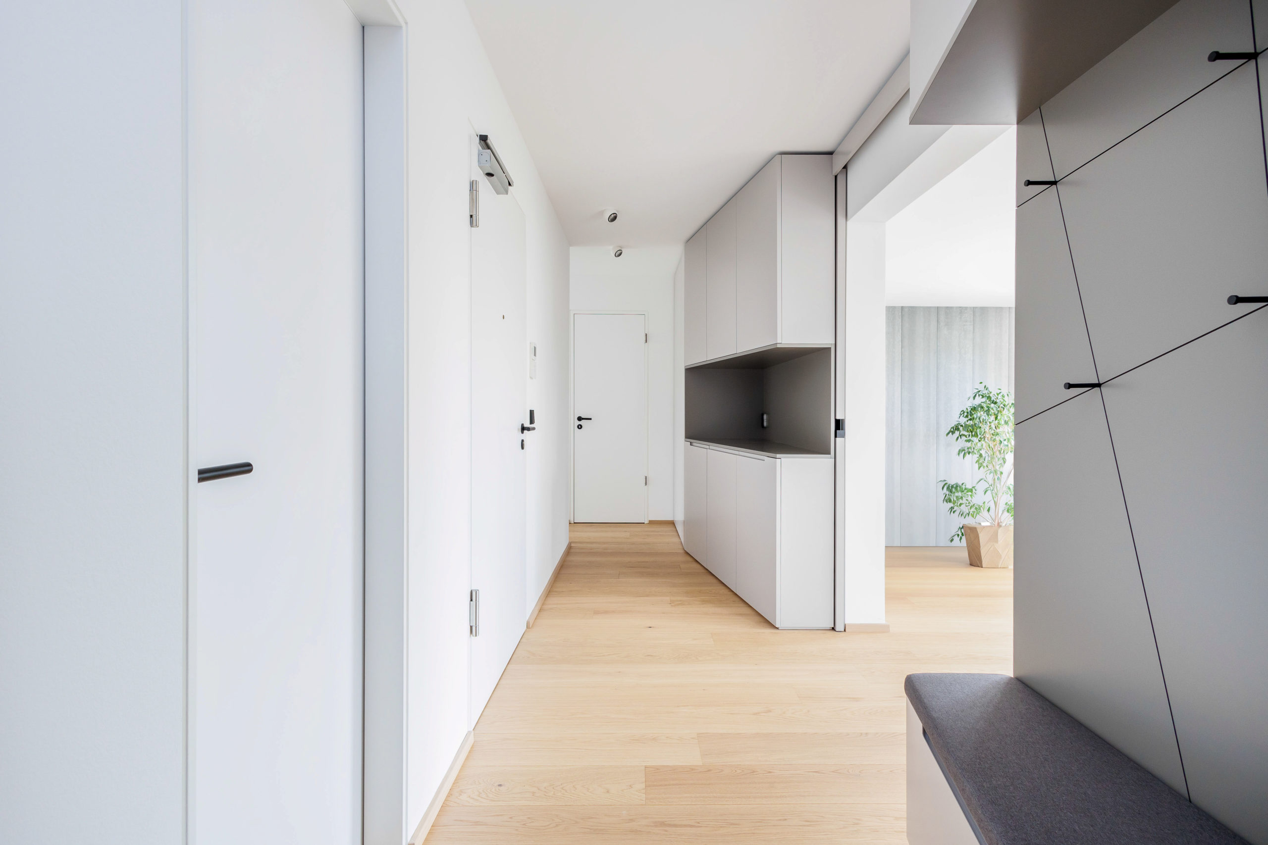 Moderner Flur mit maßgefertigtem Einbauschrank und hellem Eichenparkettboden