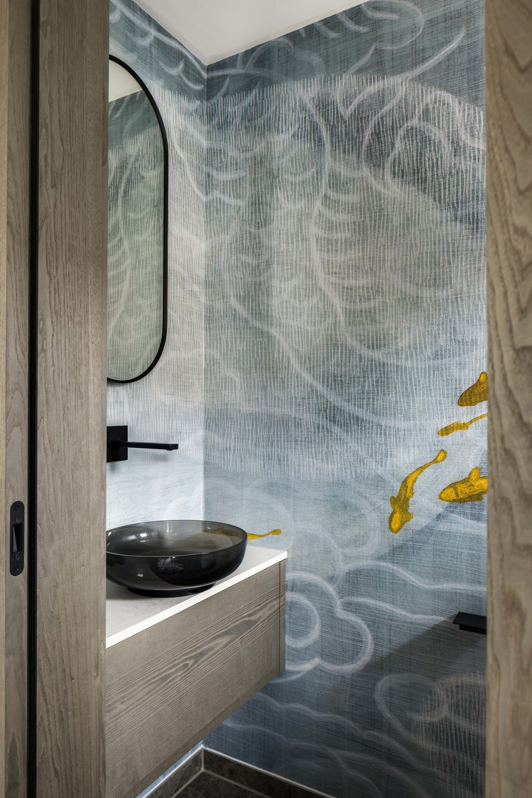 Exklusives Gäste-WC mit Wandtapete im Koi-Fisch-Design, hängendem Holzwaschtisch und schwarzem Waschbecken.