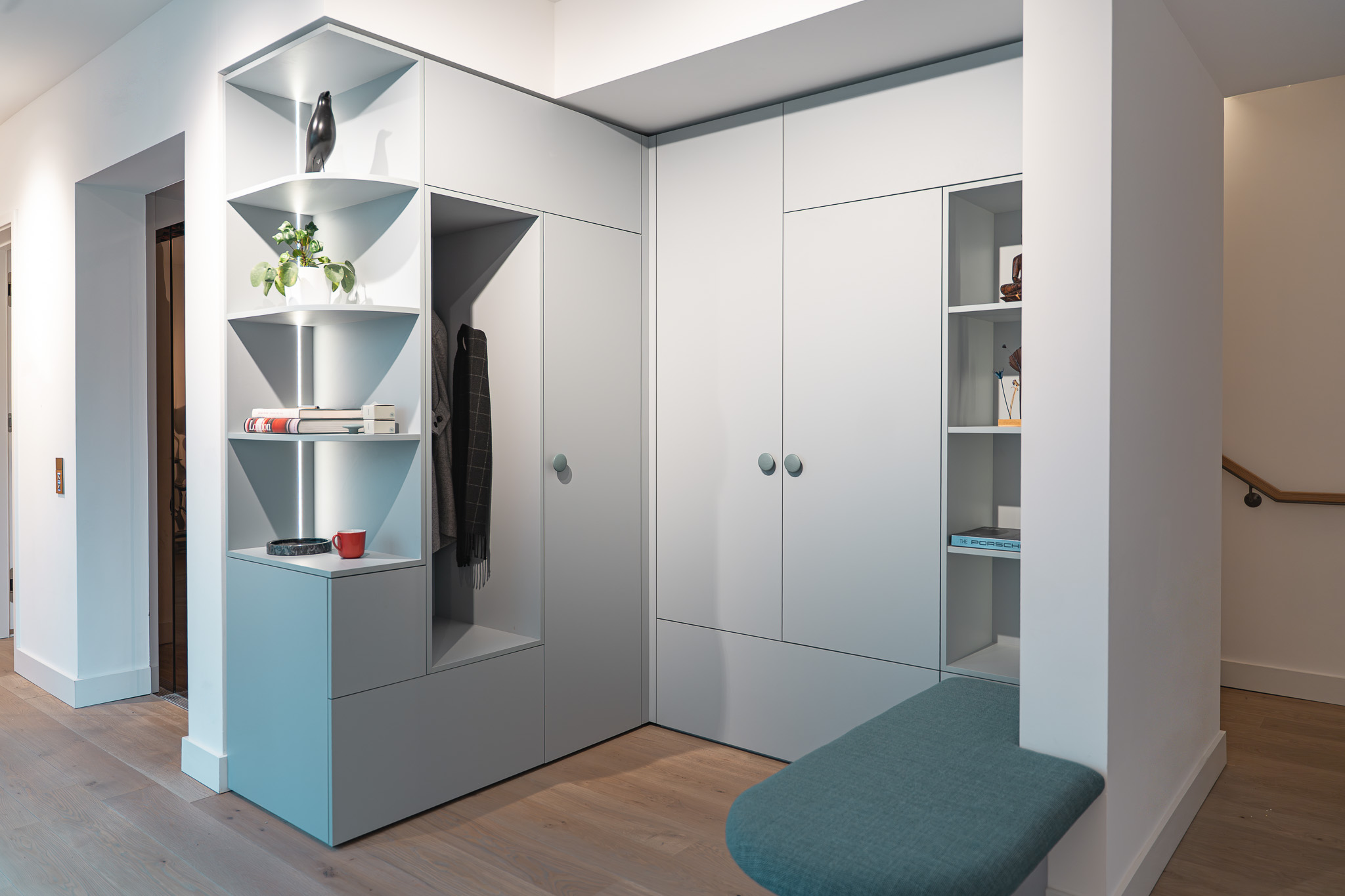 Offene Garderobenlösung mit Eckschrank, Regalfächern und integrierter LED-Beleuchtung in modernem Design.