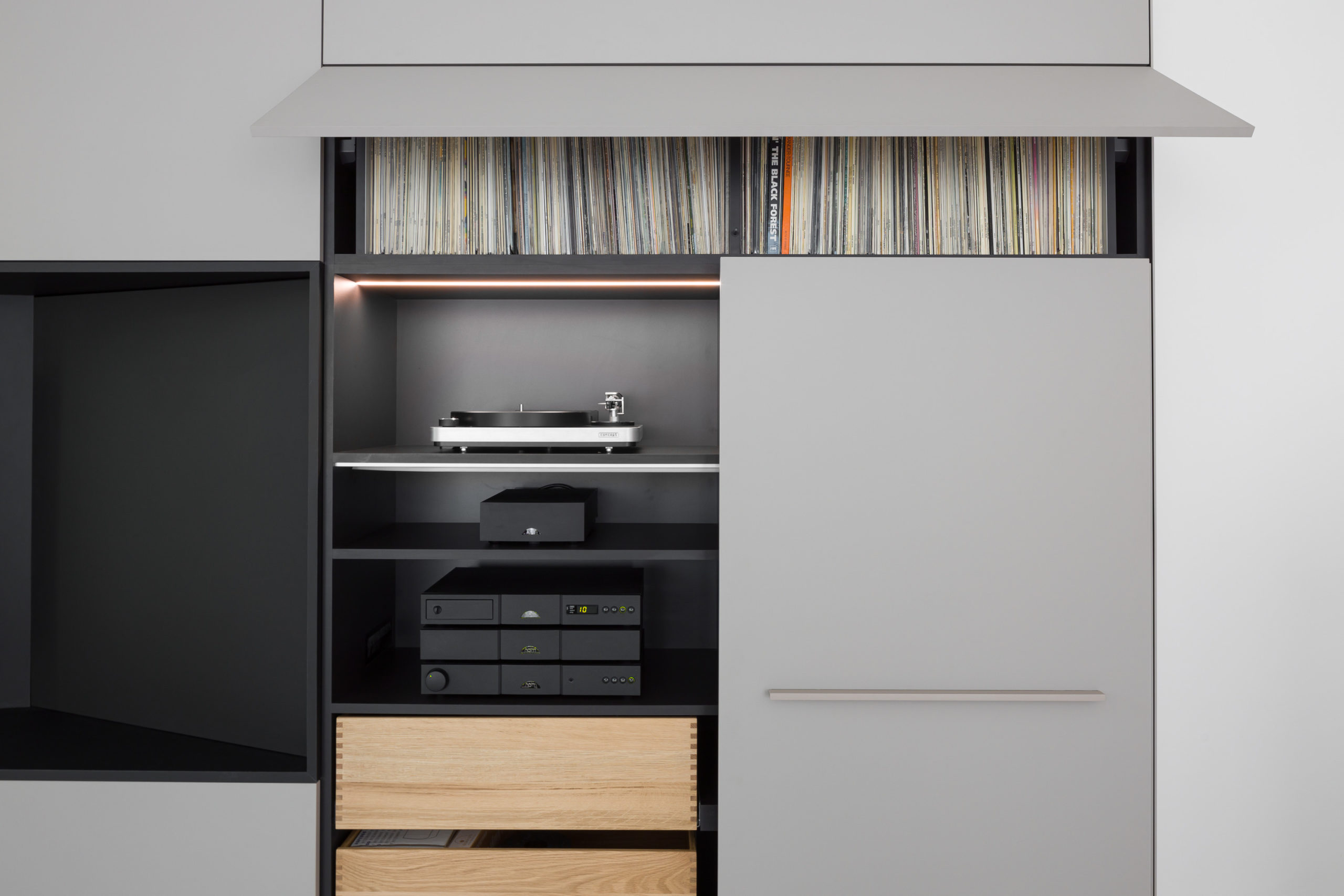 Wohnzimmer mit geöffnetem HiFi-Schrank, Plattenspieler und Verstärkeranlage