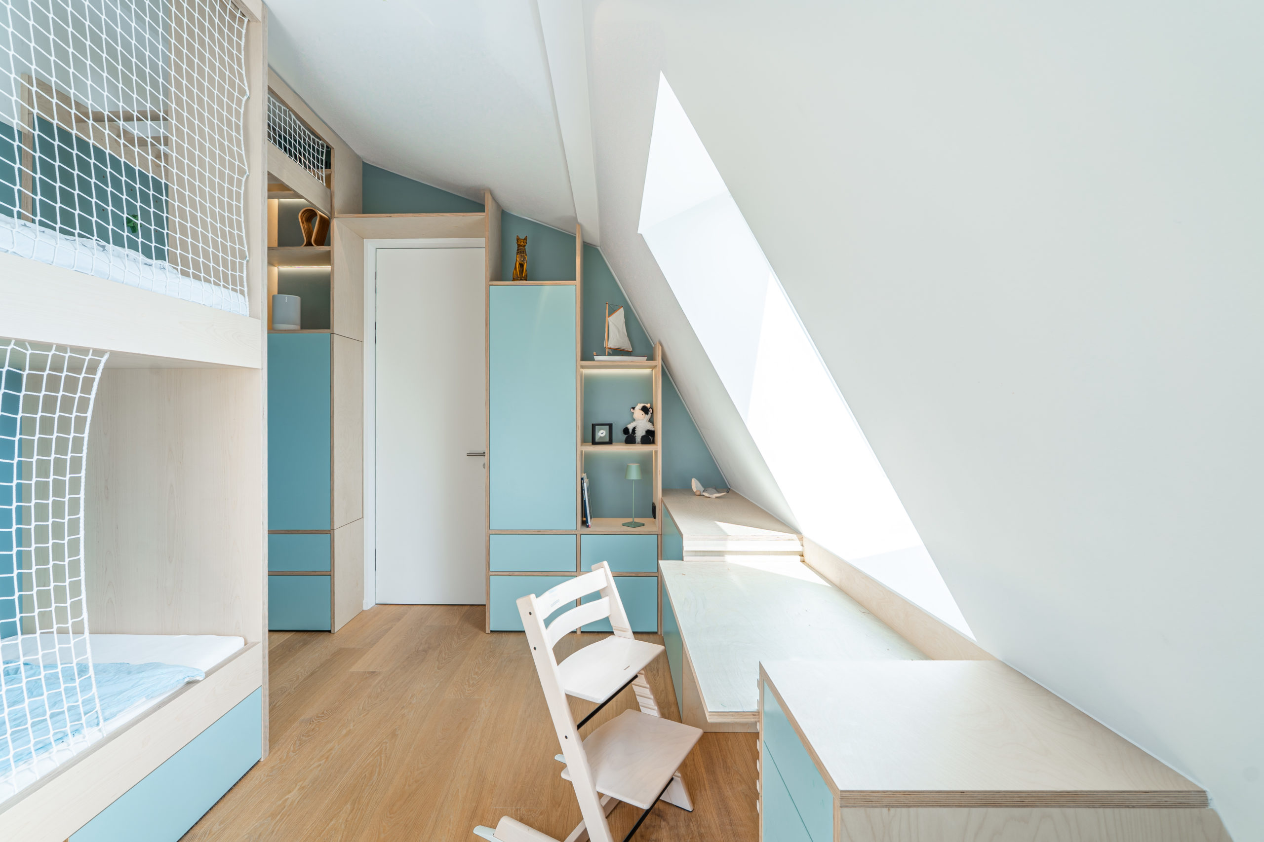 Detail Kinderzimmer mit Dachschräge, Stauraum und Hochbett in Blau – exklusiver Innenausbau und Möbeldesign