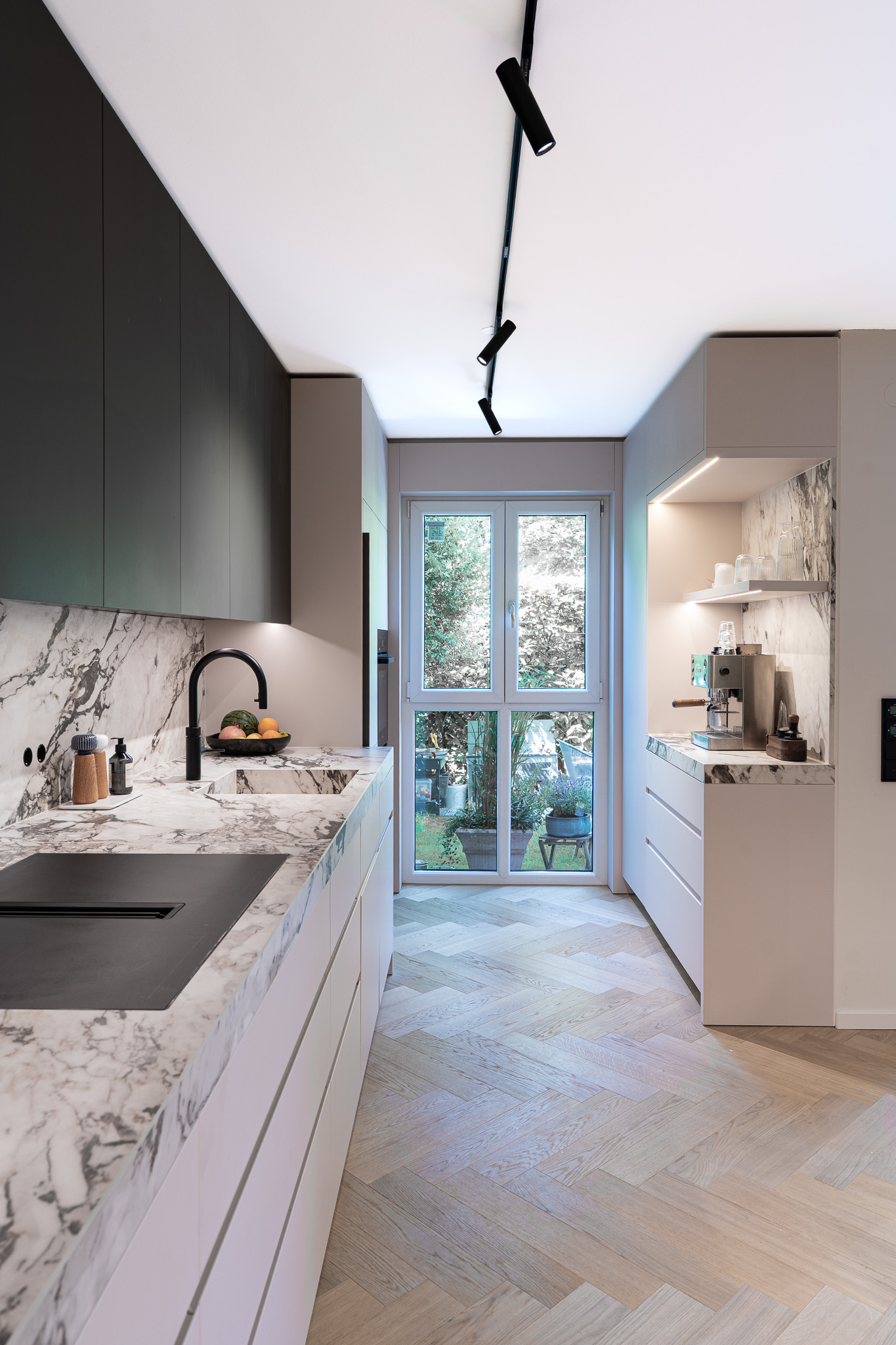 Lichtdurchflutete Küche mit großem Fenster, Marmorarbeitsplatte und modernem Innenausbau, München