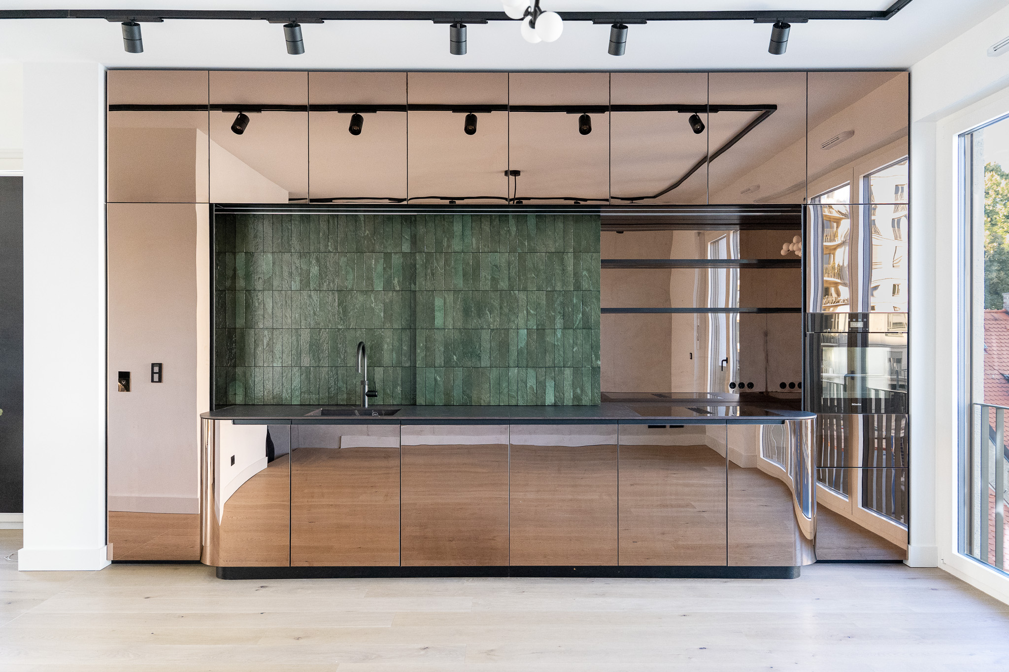 Luxus-Küche mit grüner Fliesenrückwand, schwarzer Arbeitsplatte und modernen Details