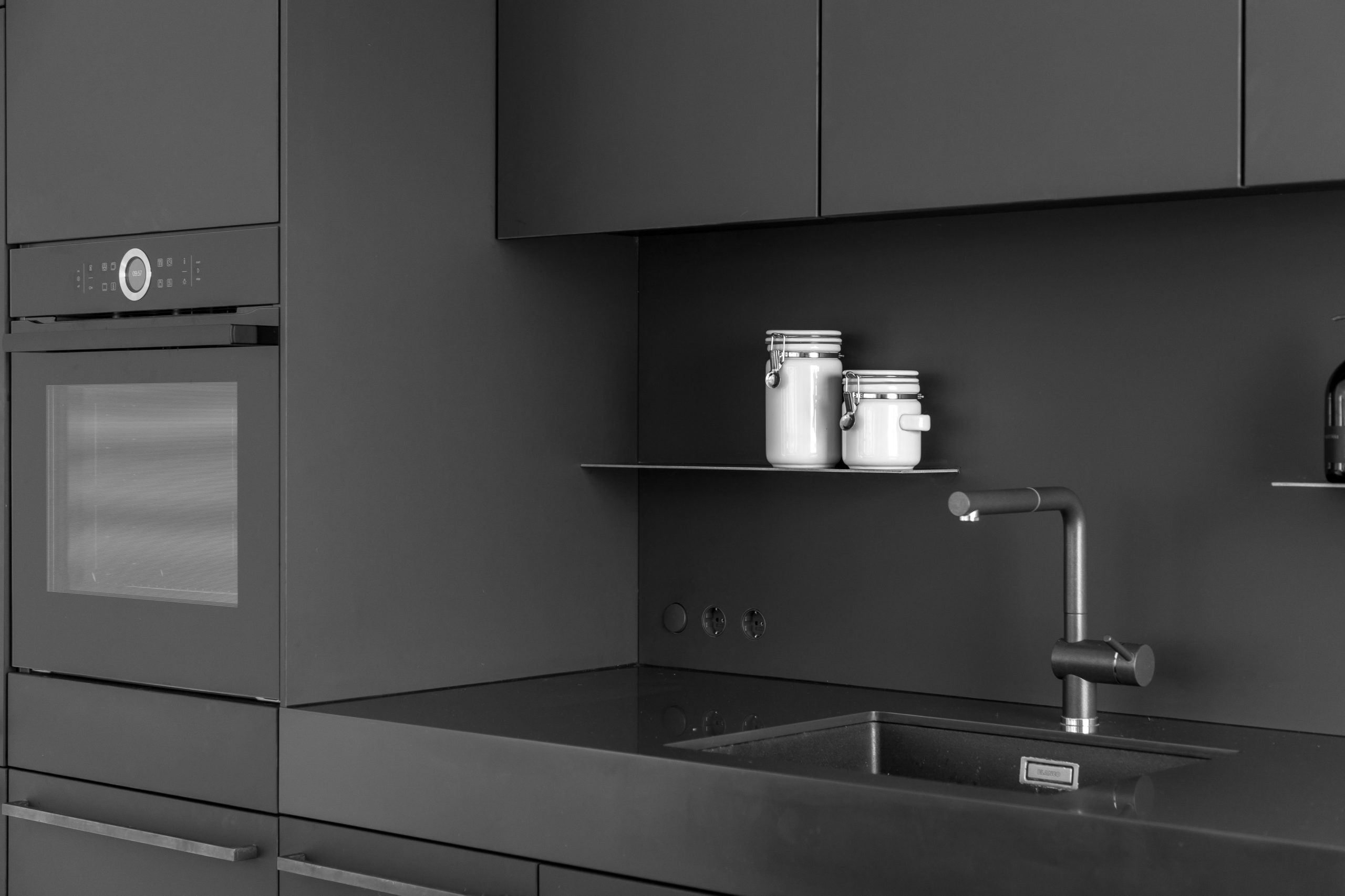 Seitenansicht eines deckenhohen Einbauschranks mit Eiche-Furnier in Fischgrätoptik, in einen eleganten Altbauflur mit Hohlkehle und dezentem Farbschema integriert.