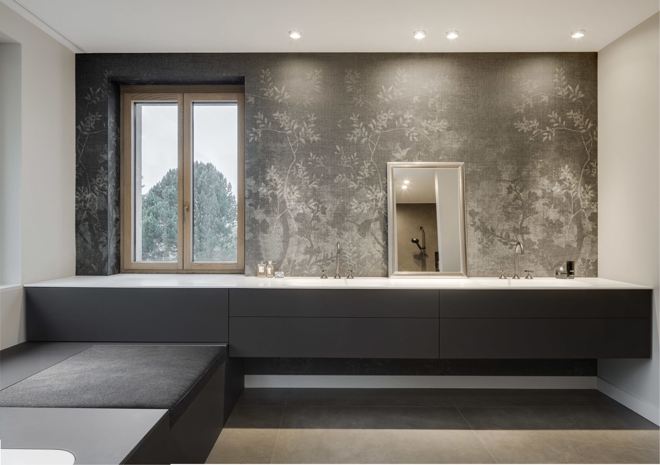 Modernes Badezimmer mit Doppelwaschtisch, floral gemusterter Tapete und großem Fenster