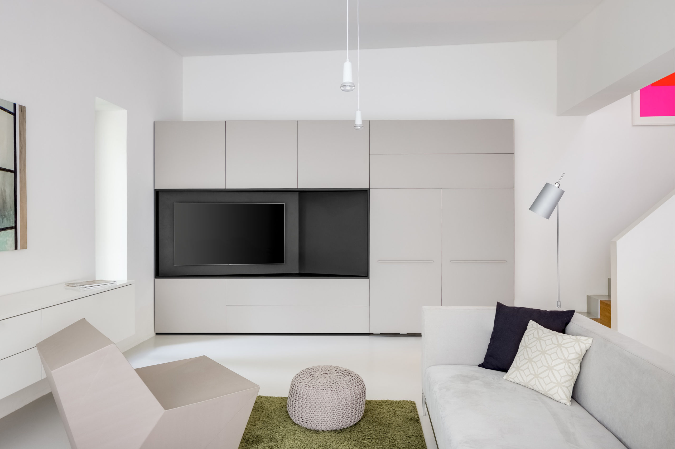 Modernes Wohnzimmer mit geschlossener Schrankwand und integriertem Fernseher