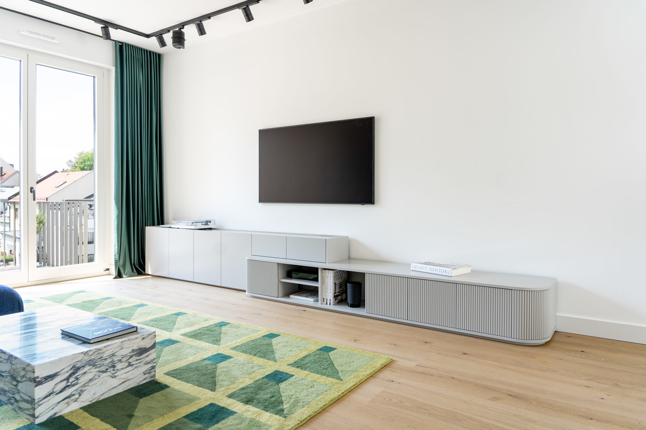 Modernes, maßgefertigtes Lowboard im Wohnzimmer mit TV-Wand, offenen Regalen und geschlossenen Schränken.