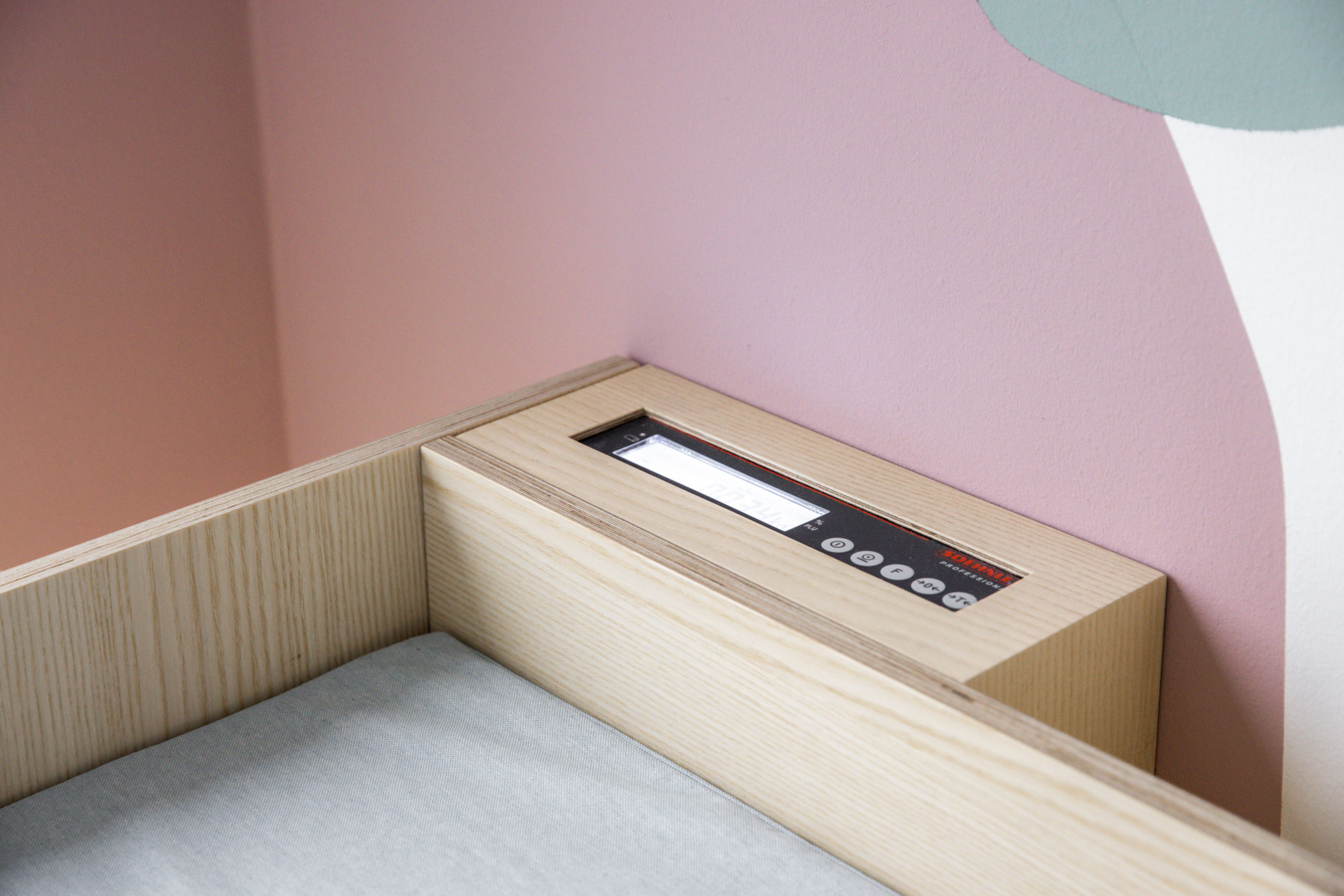 Detail der integrierten Waage in einer Behandlungszeile, helle Holzoptik.