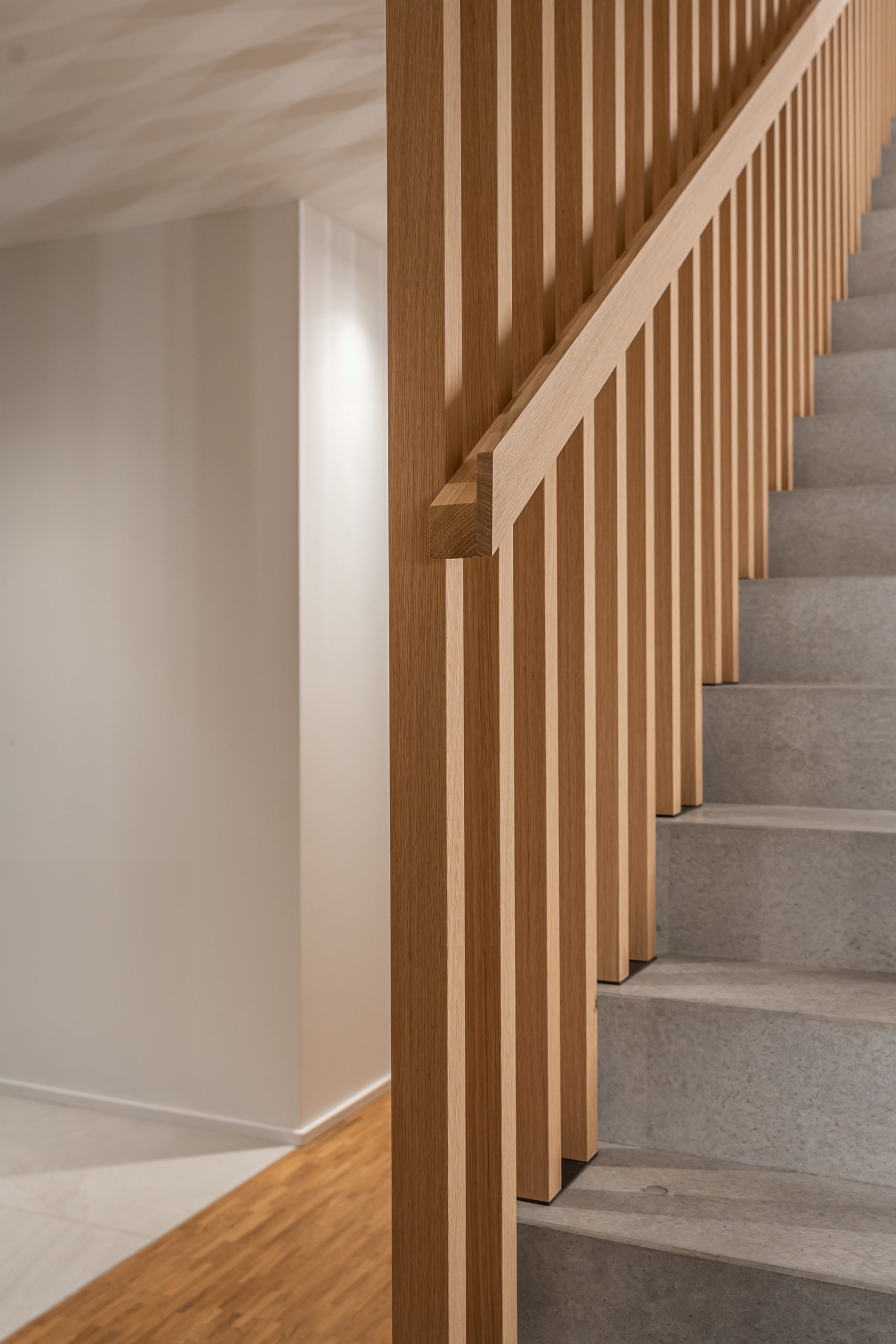 Modernes Treppengeländer aus massiver Eiche mit minimalistischer Linienführung im hochwertigen Innenausbau