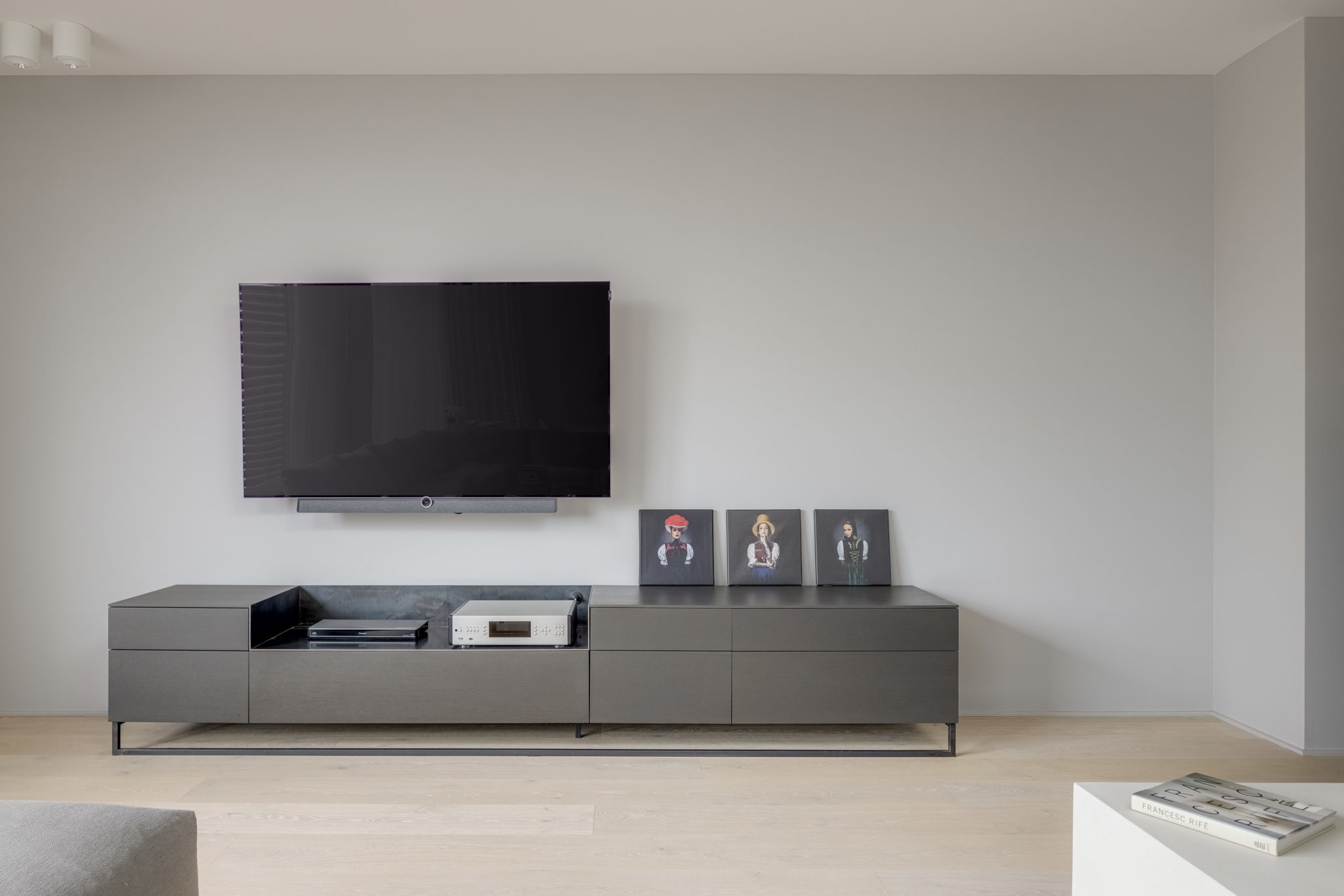 Modernes TV-Möbel in minimalistischem Interior Design mit dunkler Furnieroberfläche