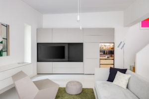 Wohnzimmer mit Einbauschrank, geöffnetem Barfach und integrierter Beleuchtung
