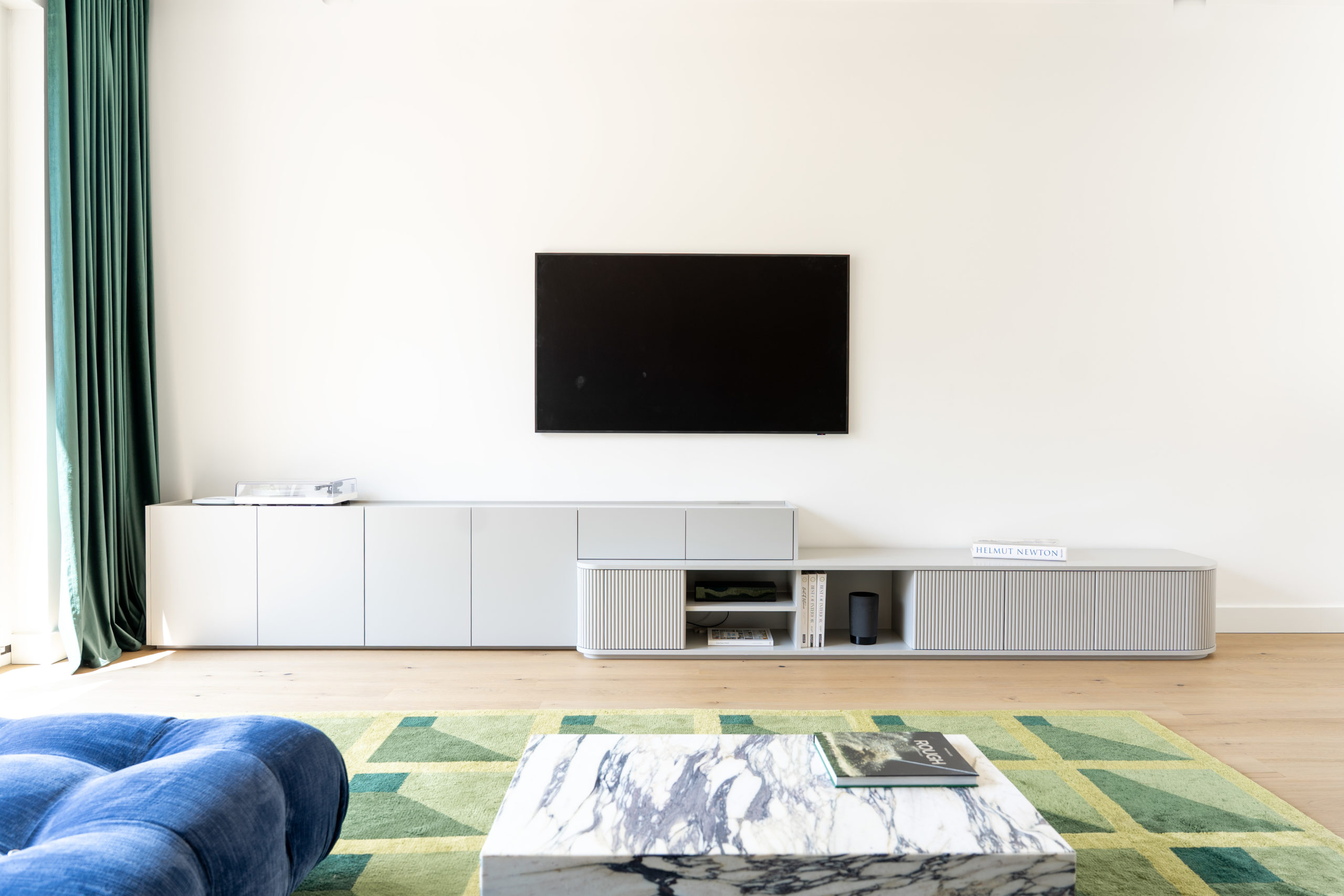 Modernes, maßgefertigtes Wohnzimmer-Lowboard in Grau mit offenen Fächern und geschlossenen Elementen.
