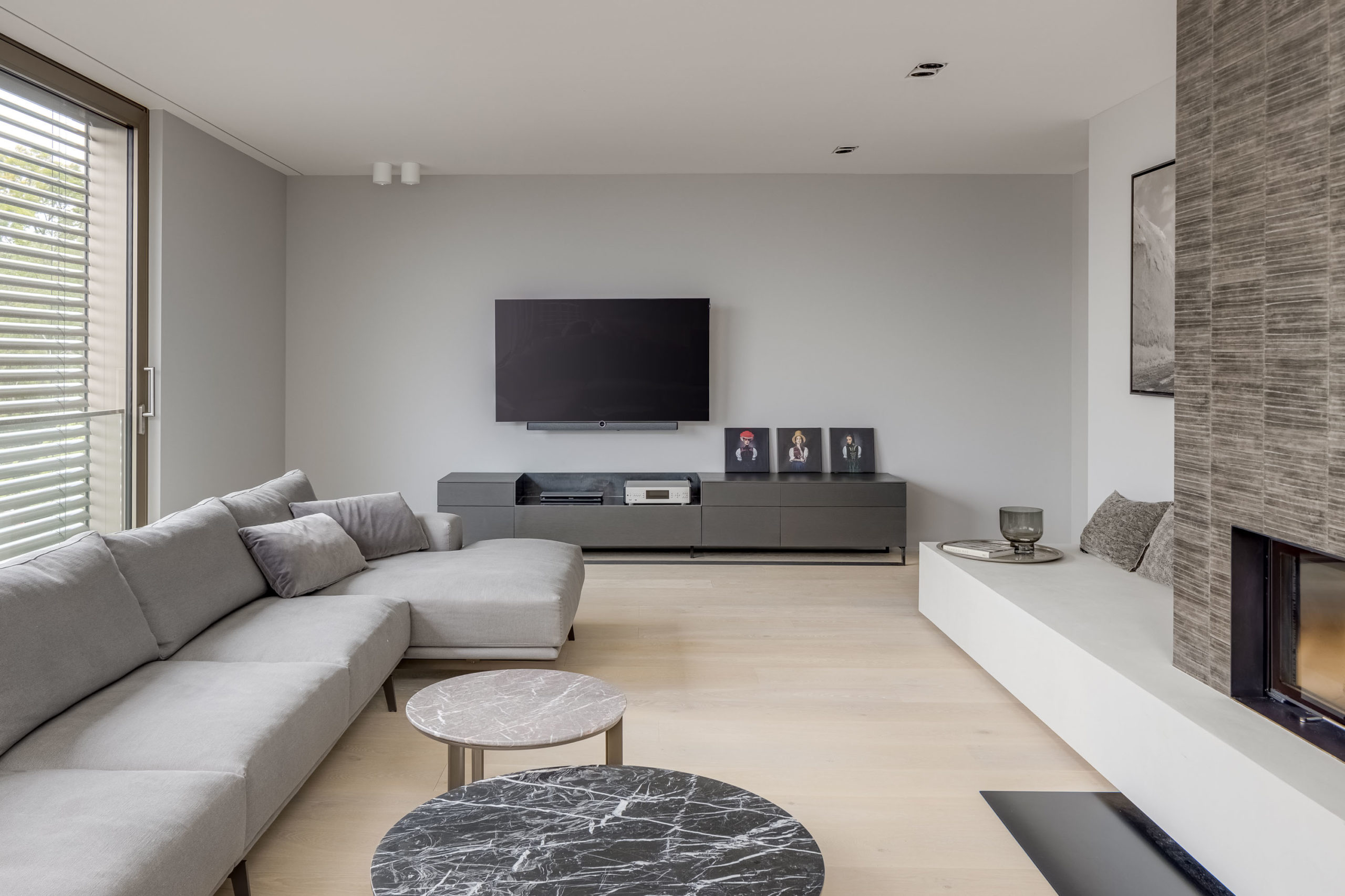 Modernes Wohnzimmer mit furniertem TV-Sideboard und Wandmontage-Fernseher