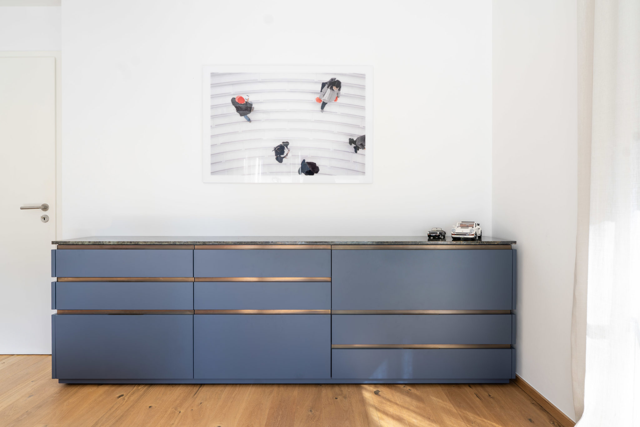Modernes Sideboard in Blau mit Holzdetails und Natursteinplatte, maßgefertigt für hochwertigen Innenausbau.